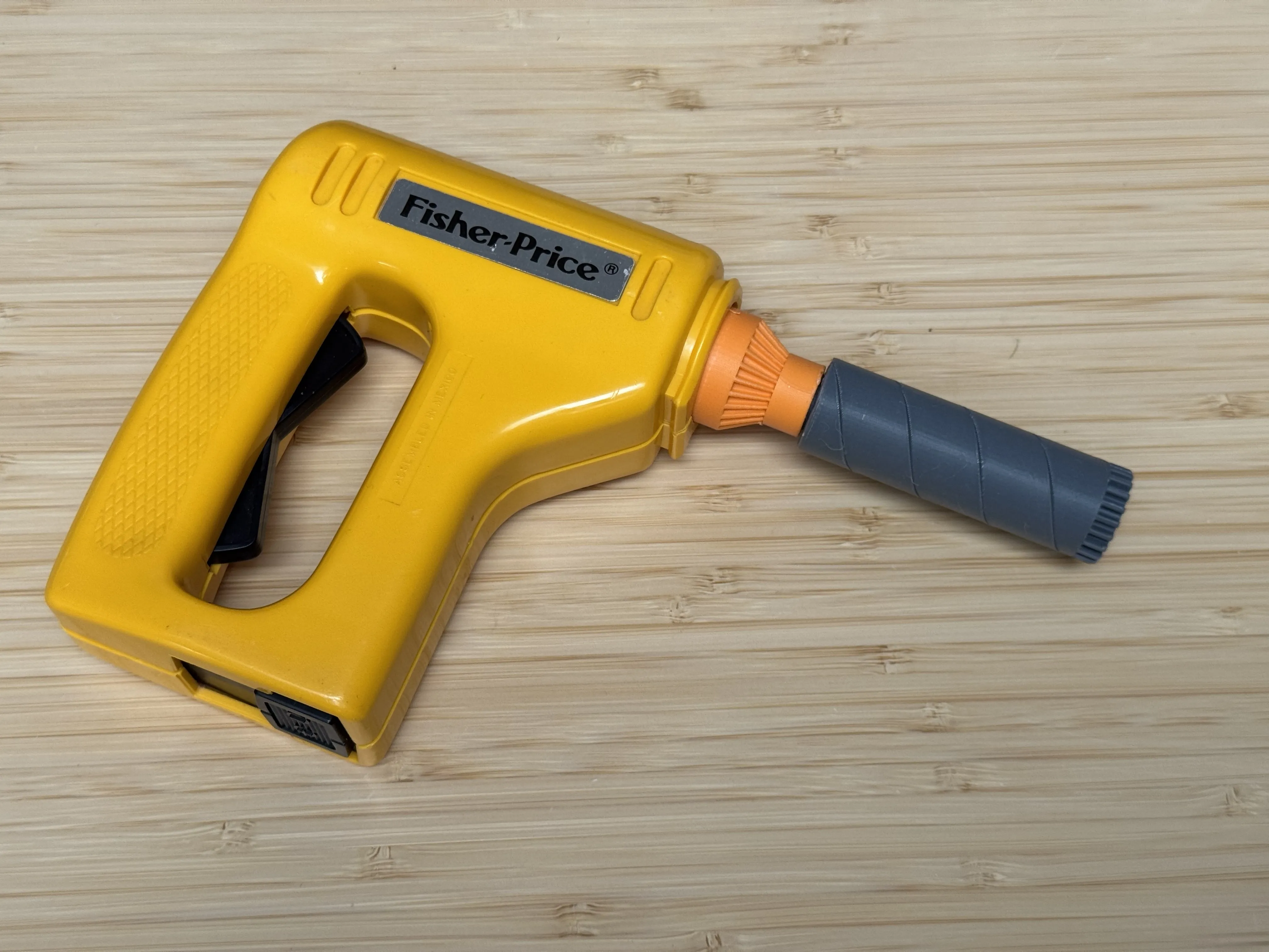The drill bit attachment plugged into the toy's yellow power handle