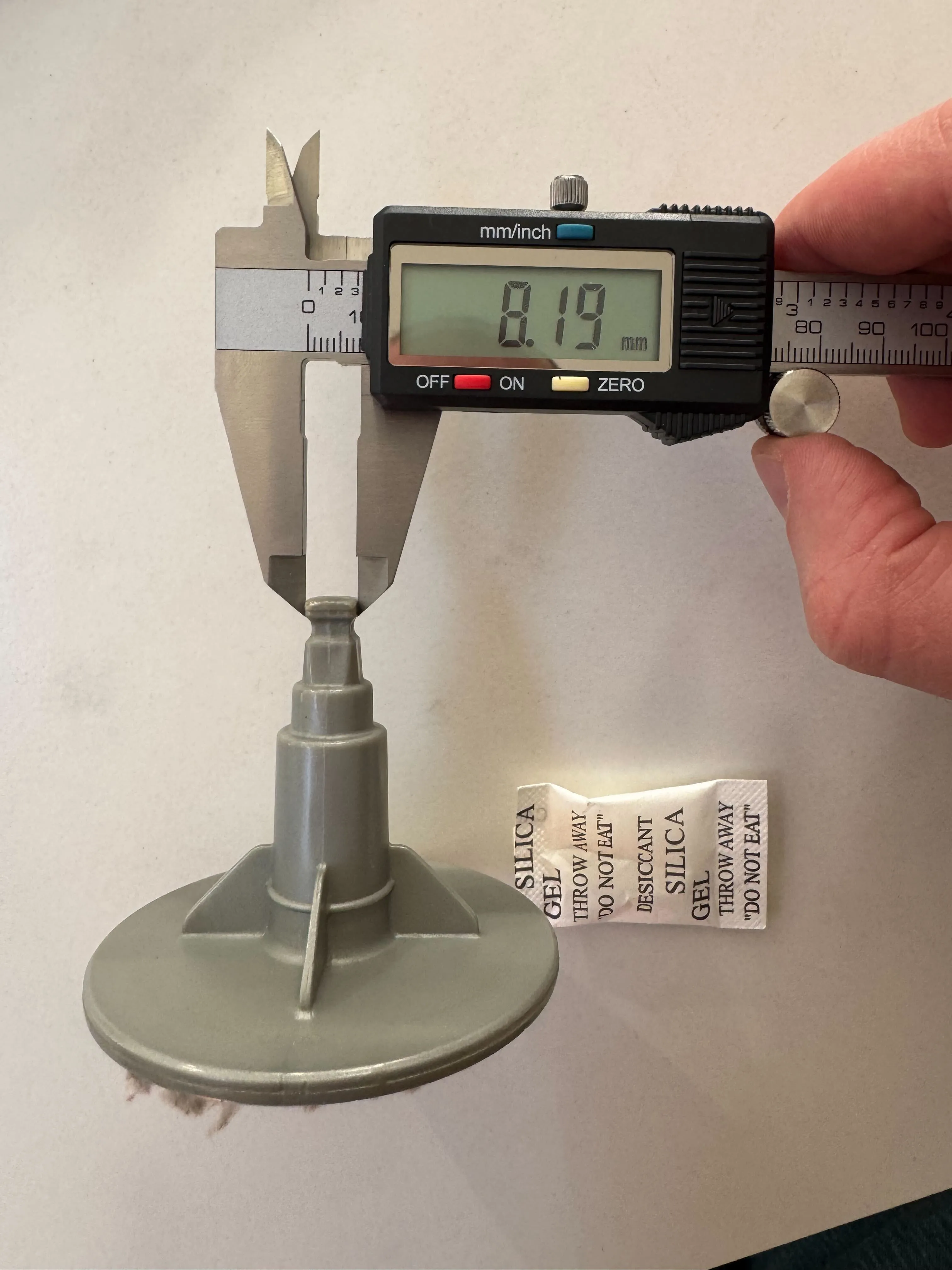 A printed drill-socket attachment measured with calipers reading 8.19 mm